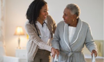 Medical professional walking patient through rehab