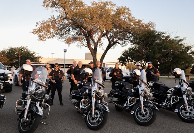 Police posing with their motorcycles at NWTHS flag raising